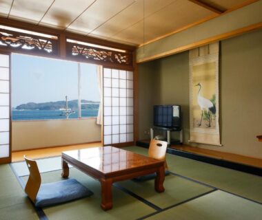 Traditional tatami room with low table and shoji doors opening to sea view at Bekkan Yosanoso in Kyoto