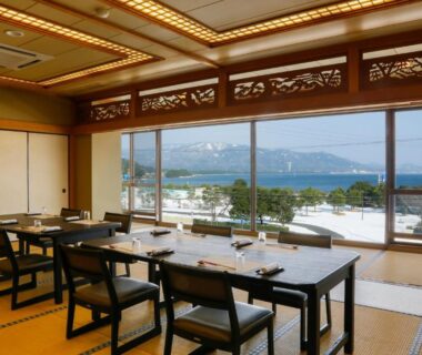 Tatami dining room with low tables and water view at Bekkan Yosanoso, Kyoto