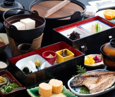 Assorted Japanese breakfast with grilled fish, tamagoyaki, tofu, miso soup and side dishes in lacquered boxes