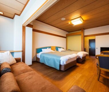 Twin beds with sofa, wooden flooring and shoji screen at Beppu Kannawa Onsen Oniyama Hotel, Oita