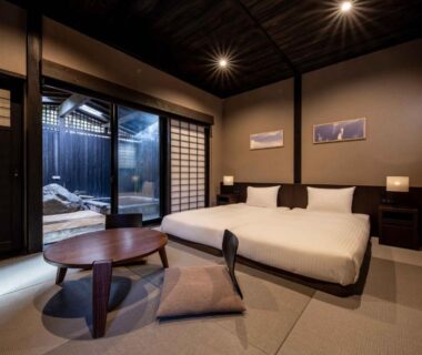 Tatami floor room with low table, cushions, twin low beds, shoji screens and glass-walled bathing alcove