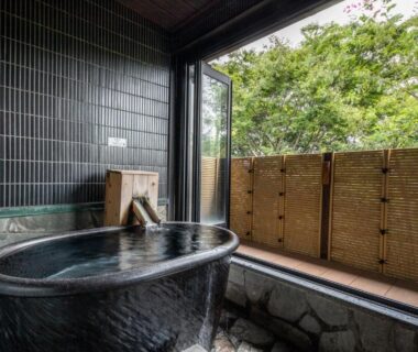 Stone bath opening to bamboo-screened garden at Beppu Nagomitsuki ryokan, Ōita