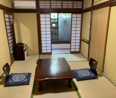Traditional tatami room with low wooden table, floor cushions and shoji screens at Beppu no Oyado Kagaya, Ōita