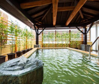 Roofed communal onsen bath with stone feature at BeppuOnsen Hotel Sansenkaku Ōita Kyūshū