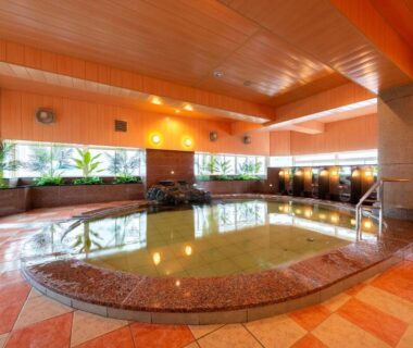 Spacious indoor communal onsen with tiled bath and washing stations at BeppuOnsen Hotel Sansenkaku, Ōita, Kyūshū