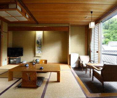 Traditional tatami room with low wooden table, shoji screens, tokonoma alcove, seating area overlooking greenery at Besshoonsen Nanjyo Ryokan