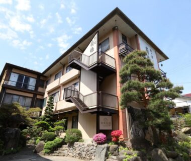 Three-story ryokan exterior with landscaped garden at Besshoonsen Nanjyo Ryokan, Nagano Prefecture