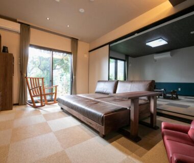Tatami seating area and sofa at Bettei Fujiya in Hiroshima with sliding doors to garden