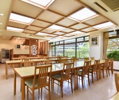 Bright dining area with wooden tables and garden-facing windows at Bijintei in Wakayama, Kansai