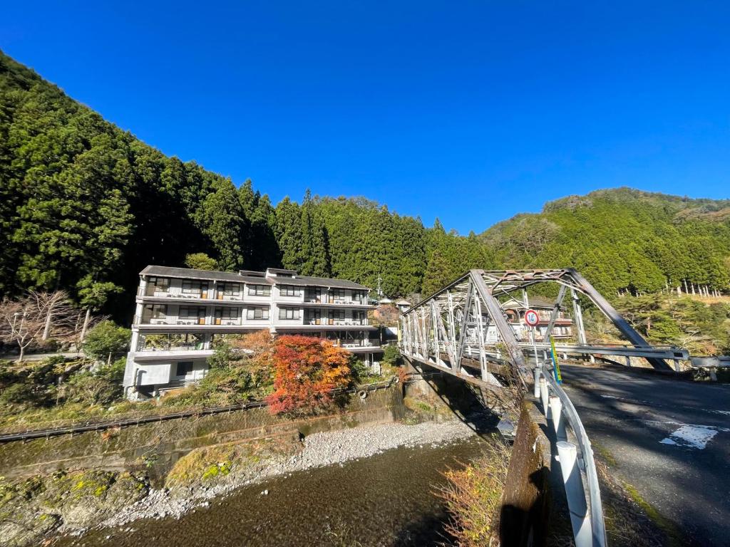 Bridge and riverside Bijintei Wakayama Kansai Bridge over river with Bijintei ryokan beside forested hills in Wakayama Kansai