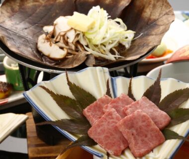 Thin beef slices on ceramic plate with garnish, mushrooms and shredded vegetables on a Japanese dining table