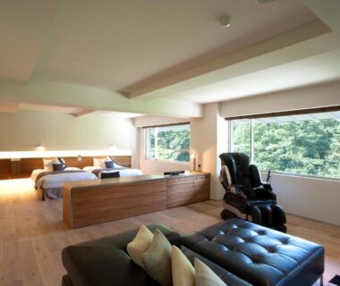 Bright modern guest room with lounge seating, twin beds, and massage chair at Bourou NOGUCHI Noboribetsu in Hokkaidō