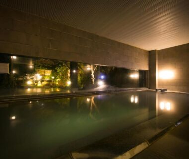Dimly lit indoor onsen bath at Bourou NOGUCHI Noboribetsu with night garden view in Hokkaidō
