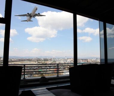 Window seating overlooking city with airplane passing above, Bourou Noguchi Hakodate, Hokkaidō