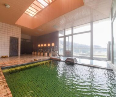 Green tiled indoor onsen bath with skylight and large windows at Bousenkaku, Niigata, Chūbu region