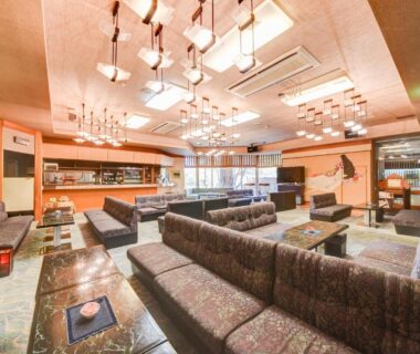 Indoor lounge with sofas, low tables, and chandelier lighting at Bousenkaku in Niigata