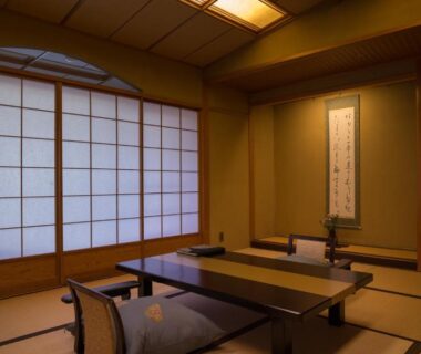 Tatami room with low table, shoji screens, tokonoma alcove and floor cushions at Bousui, Shizuoka
