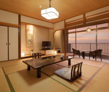 Traditional tatami room with low table, tokonoma alcove and balcony overlooking sea at Boyokaku, Kumamoto