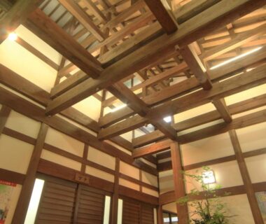 High exposed wooden beams and shoji screens in interior hall at Bunanoyado Koase, Niigata Chūbu