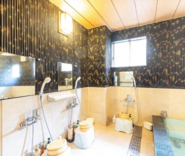 Shower stations, stools and tiled indoor bath at Business Ryokan Akashiya Annex, Hyōgo, Kansai