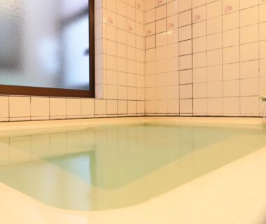 Small indoor tiled bath with frosted window at Business Ryokan Iroha in Chūbu, Gifu