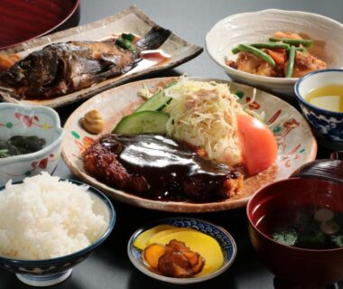 Rice bowl, miso soup, sauced meat patty, grilled fish and side dishes at Business Ryokan Iroha in Gifu, Chūbu