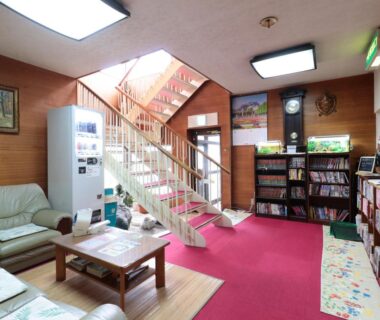 Lobby with sofas, vending machine, staircase and bookshelf at Business Ryokan Iroha, Gifu