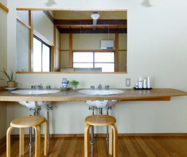Double vanity with mirrors, wooden counter, stools and toiletries in ryokan wash area at Busuitei, Gifu