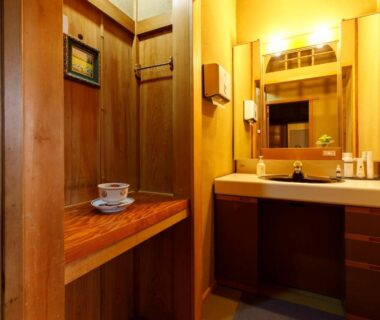 Warm wooden vanity area with sink, mirror, bench and tea cups at Busuitei in Gifu, Chūbu