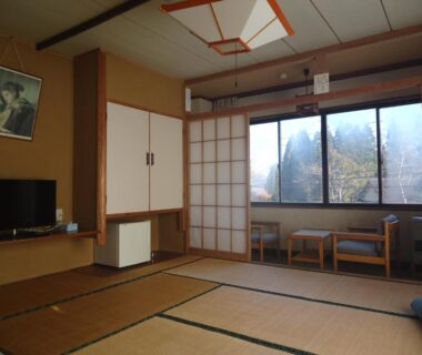 Tatami room with shoji screens, low chairs by window and TV at Cafe Cerisier栖里時絵 in Niigata