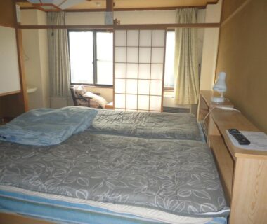 Twin beds and shoji screens in a simple ryokan room at Cafe Cerisier栖里時絵, Niigata, Chūbu