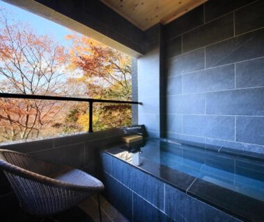 Stone tiled balcony bath with chair and autumn foliage view at Centurion Hakone Bettei, Kanagawa