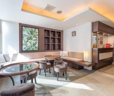 Sunlit modern lobby seating with round table, bench sofas and reception desk at Chang Tee Hotel Ikebukuro Tokyo