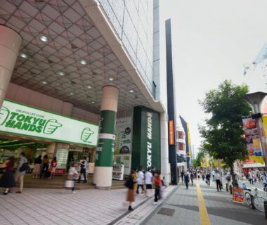 Busy pedestrian street with storefronts and Tokyu Hands signage near Chang Tee Hotel Ikebukuro, Tokyo