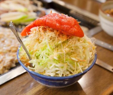 Bowl of shredded cabbage with red garnish beside teppan grill at Chang Tee Hotel Ikebukuro Tokyo