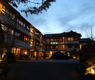 Illuminated traditional ryokan exterior at dusk with lit entrance and landscaping in Gunma, Kantō, Japan