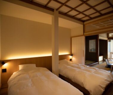 Twin beds with tatami seating, shoji screens and wooden ceiling at Chigira Jinsentei in Gunma