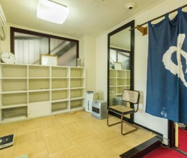 Ryokan entryway with blue noren, wooden shoe shelves, chair and raised threshold at Chojuyu Hakone, Kanagawa