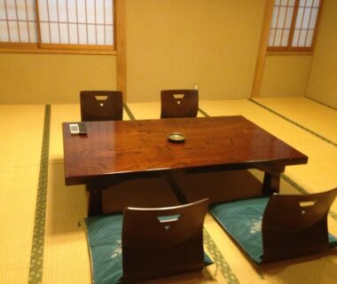 Tatami room with low wooden table and zaisu floor chairs at Chuokan Shimizuya Ryokan in Nagano, Chūbu