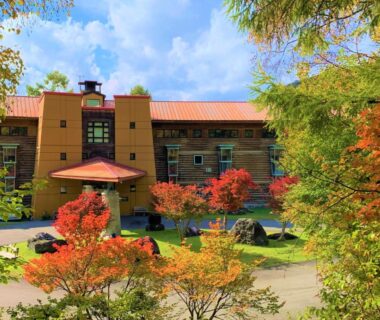 Hotel building framed by autumn maple trees and landscaped entrance at Chuzenji Kanaya Hotel in Tochigi, Kantō, Japan
