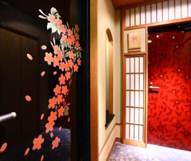 Hallway with cherry blossom decals, red floral door and shoji screens at Club Wyndham Chikumakan, Nagano