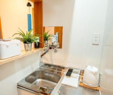 Small stainless kitchenette with sink, kettle and counter at DP小山町Machida in Tokyo