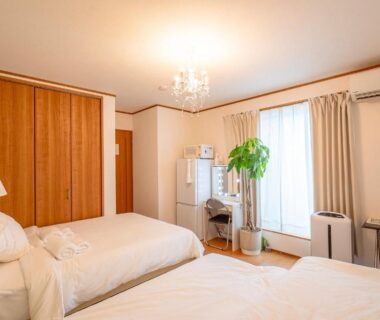 Two single beds, wooden wardrobe, chandelier and window in DP小山町Machida, Tokyo guest room