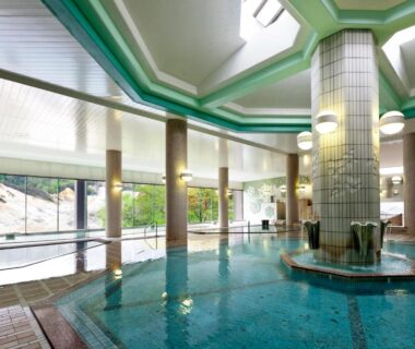 Spacious tiled indoor onsen pool with central fountain at Dai-ichi Takimotokan in Hokkaido