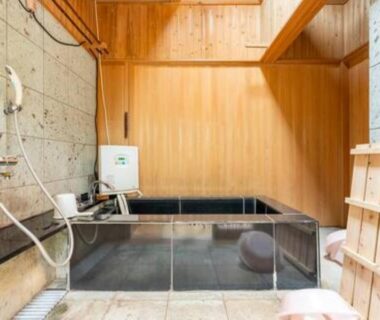 Indoor wooden soaking tub with shower station and glass barrier at Daitokuji Sushicho in Kyoto