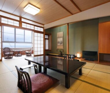 Traditional tatami room with low lacquered table, floor cushions and shoji screens at Donkairo in Hyōgo