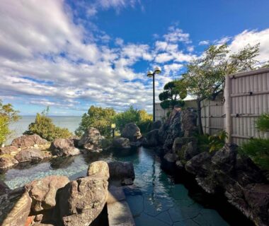 Rock-lined outdoor bath with sea and garden views at Donkairo, Hyōgo, Kansai