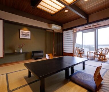 Traditional tatami room with low table, floor cushions and shoji screens opening to balcony seating at Donkairo in Hyōgo