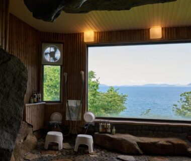 Rock-lined indoor onsen bath overlooking sea at Donkairo in Hyōgo, Kansai