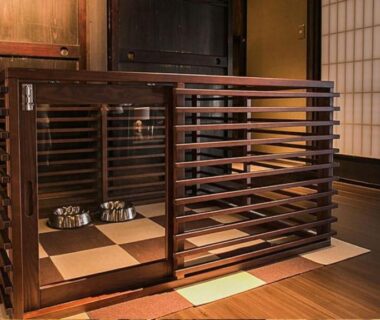 Wooden lattice partition enclosing low tatami seating with cups, shoji screens and warm wooden flooring in ryokan interior